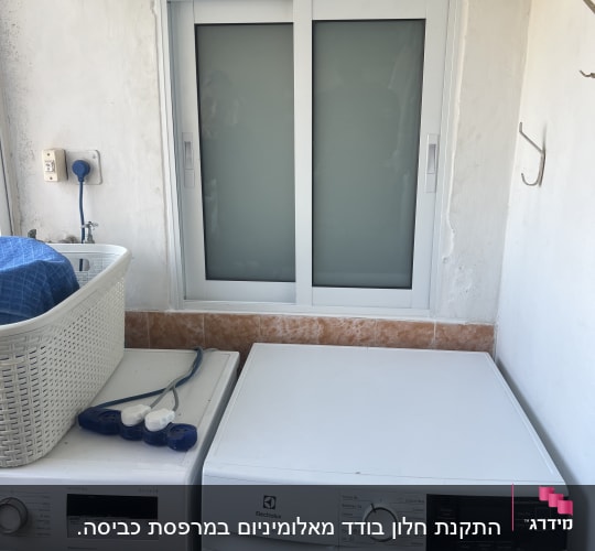 חלון אלומיניום עם מסגרת לבנה בחדר כביסה